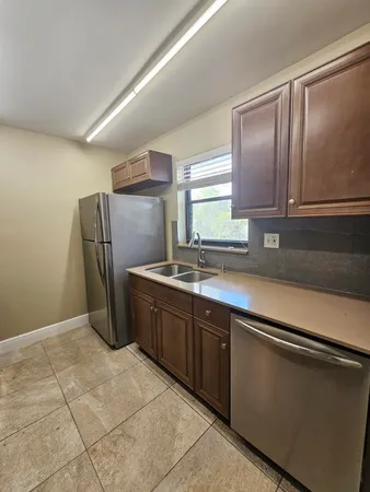 a kitchen with stainless steel appliances granite countertop a refrigerator and a sink