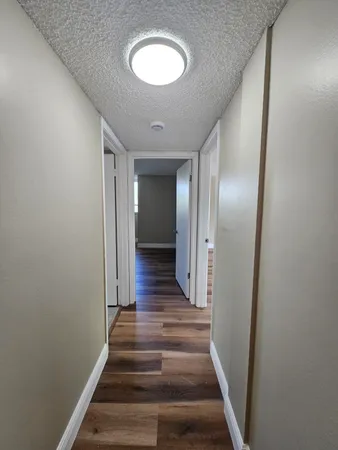 a view of a hallway with wooden floor