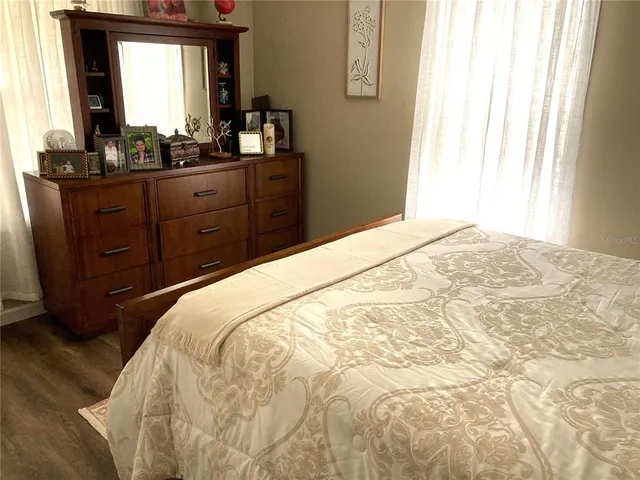 a bedroom with a bed and a mirror on dresser