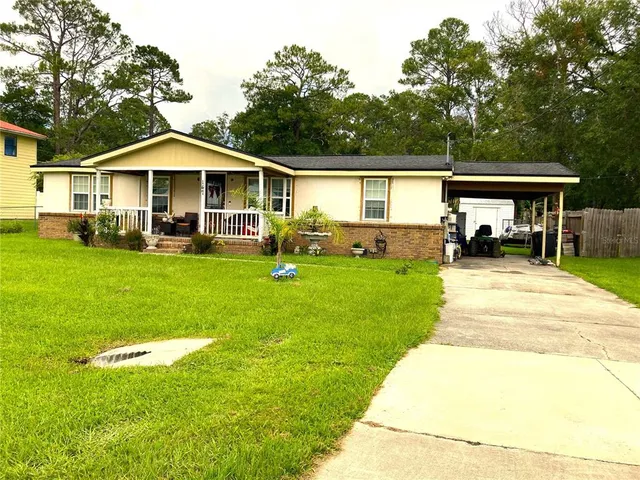 a front view of a house with a yard and trees