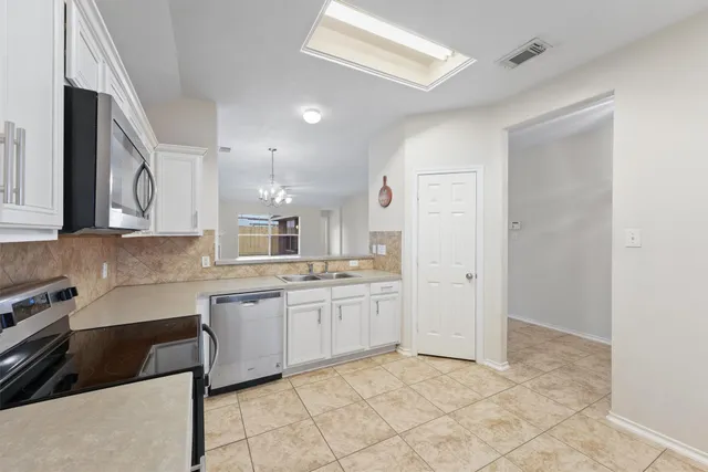 a kitchen with granite countertop a sink and white cabinets