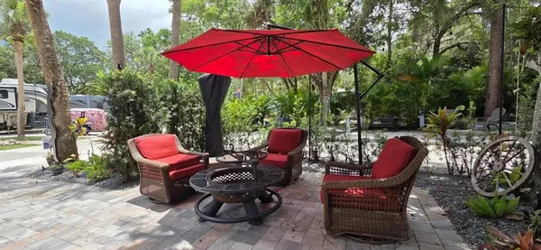 a view of a patio with table and chairs under an umbrella