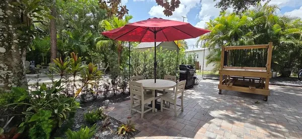 a view of a patio with chairs and a table under an umbrella