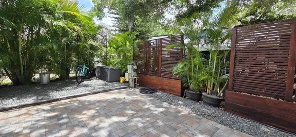 a backyard with potted plants and a large tree