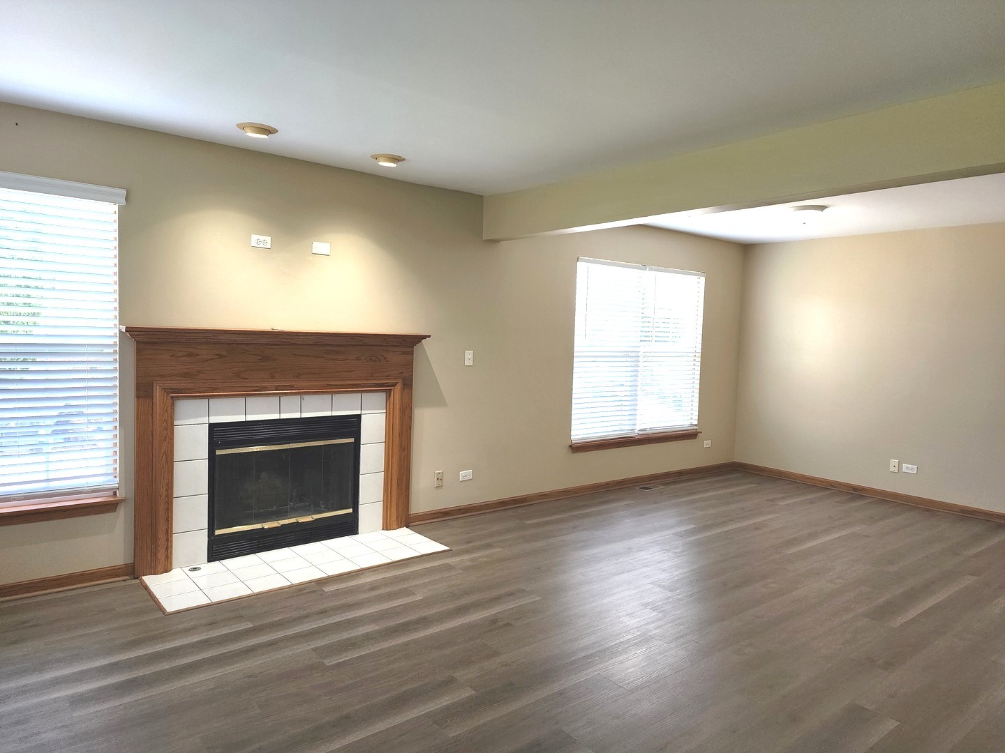775 Highview Court Antioch, IL 60002 - Photo 3 of 16 an empty room with wooden floor fireplace and windows