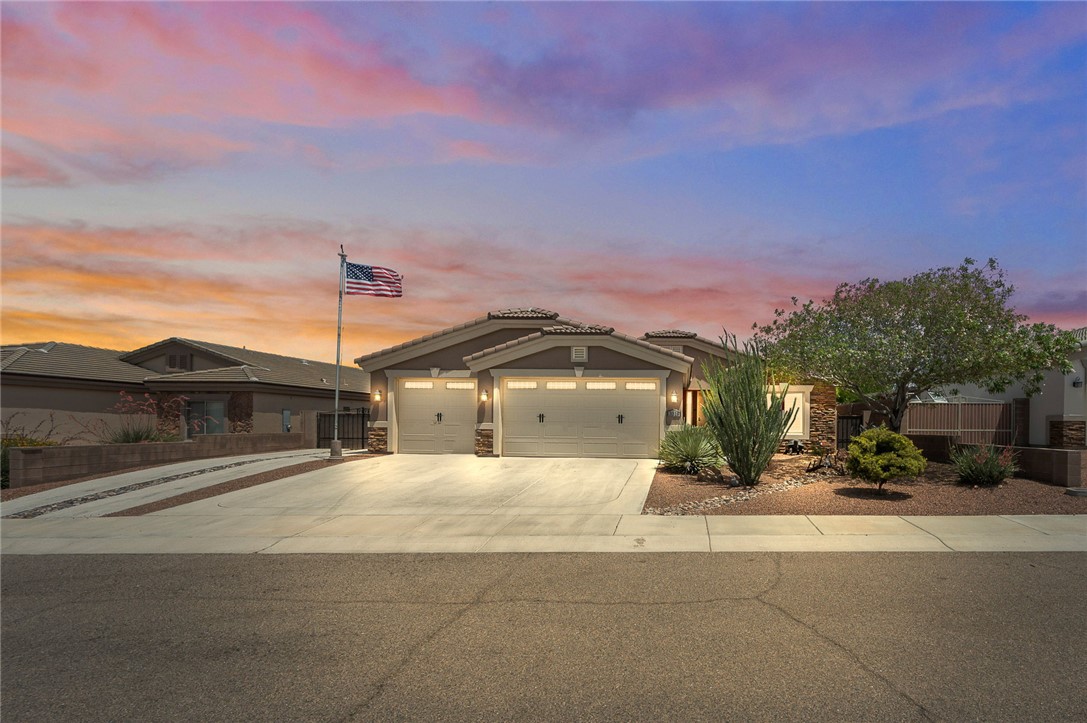 3319 Motherload Road Kingman, AZ 86401 - Photo 1 of 53 View of front of home, 3 car garage, beautiful mature landscaping, professionally installed American flag and RV parking