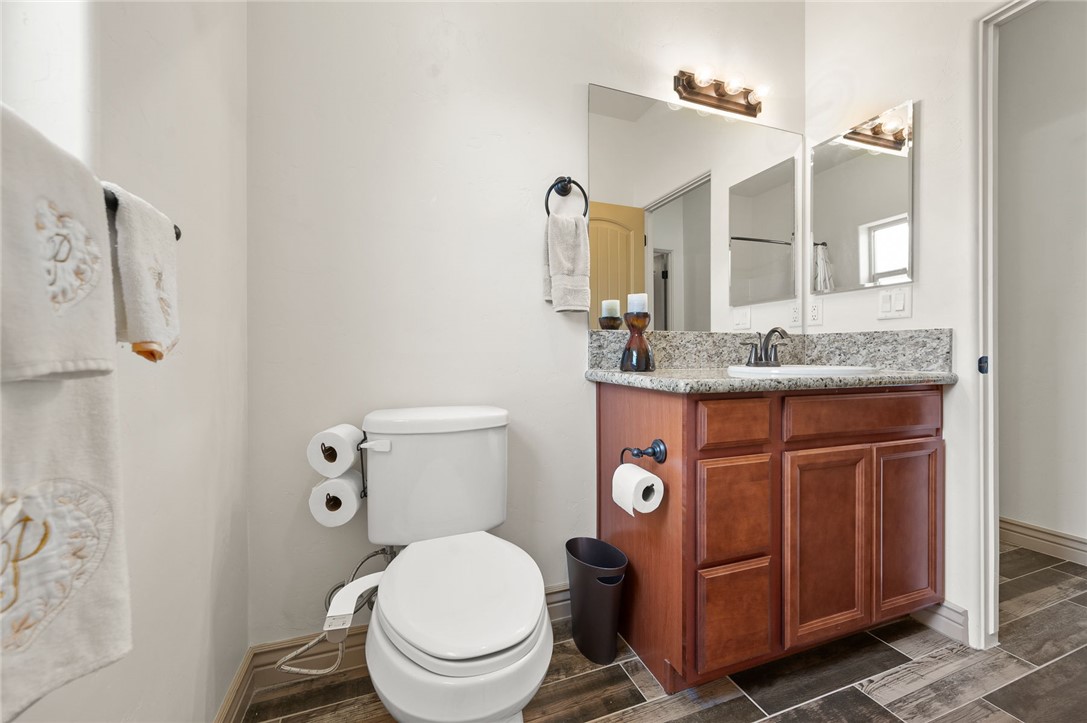 3319 Motherload Road Kingman, AZ 86401 - Photo 25 of 53 Guest bathroom featuring vanity with granite countertops, a toilet and plank tile???????????????????????????????? flooring