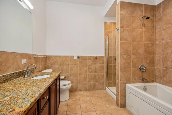 a bathroom with a granite countertop sink a toilet and bathtub