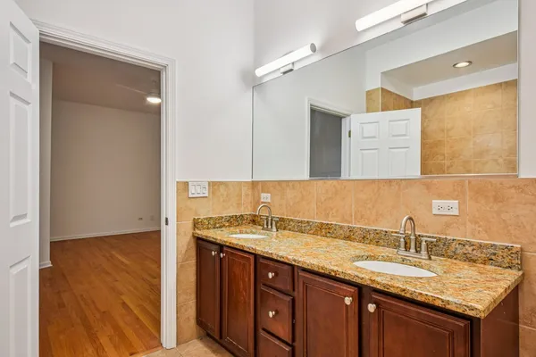 a bathroom with a granite countertop sink and a mirror