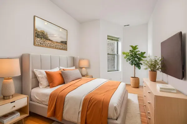 a bedroom with bed and a potted plant
