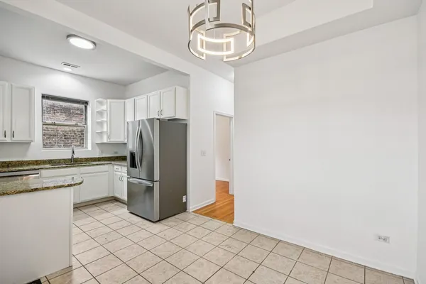 a kitchen with a refrigerator a stove cabinets and microwave