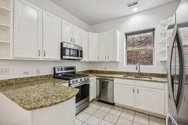 a kitchen with stainless steel appliances granite countertop a stove sink and cabinets