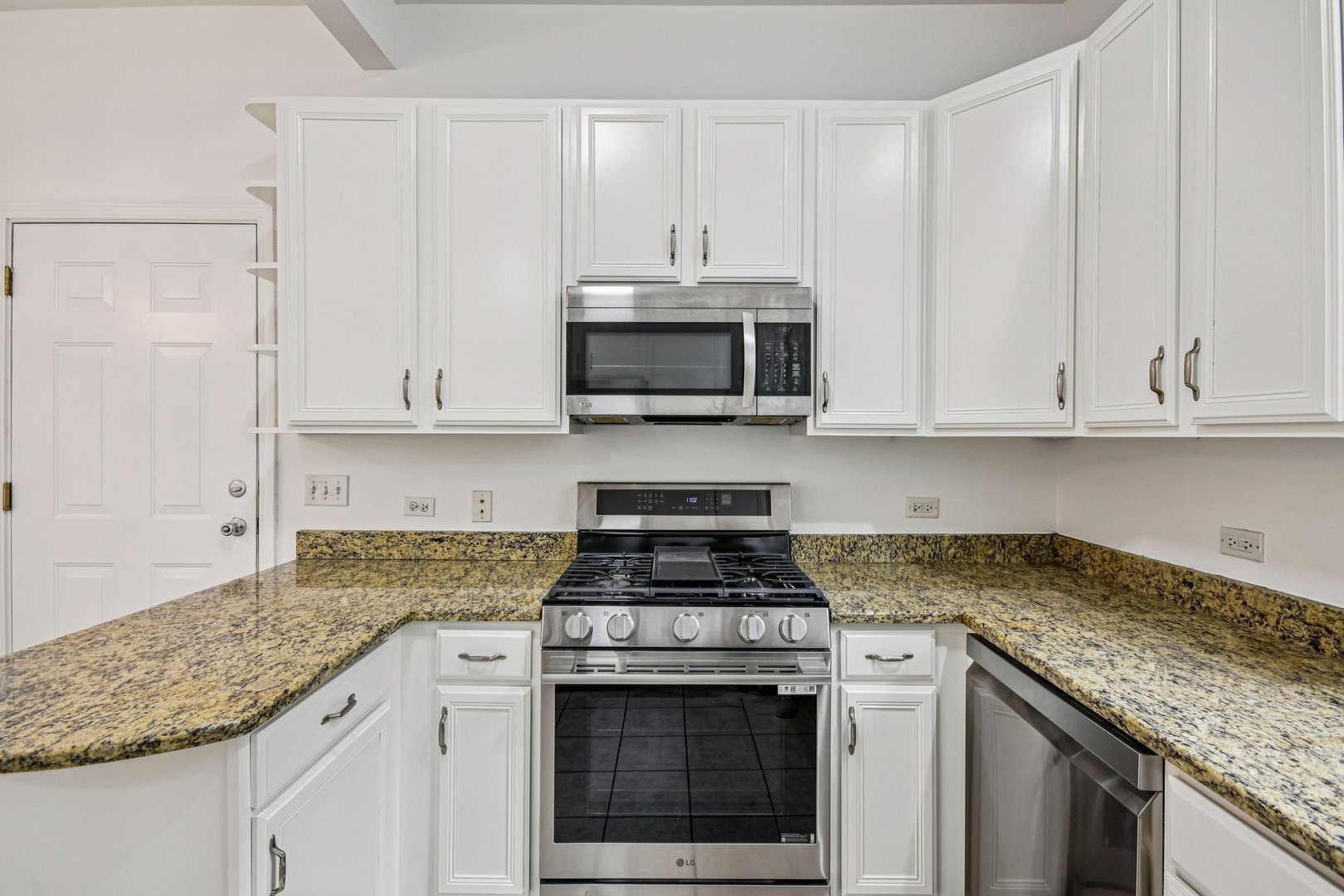 4644 South Prairie Avenue, Unit 2N Chicago, IL 60653 - Photo 8 of 25 a kitchen with granite countertop white cabinets and a stove a oven with white countertops