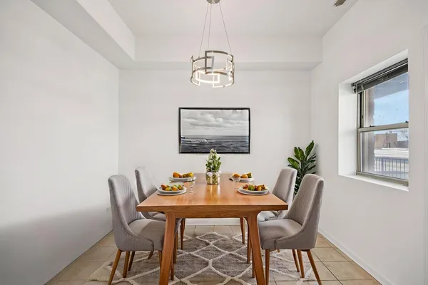 a dining room with furniture a window and a chandelier