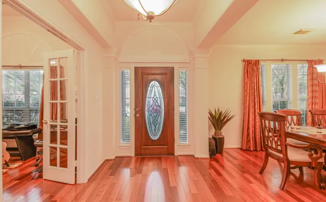 a view of a livingroom with furniture wooden floor mirror and windows