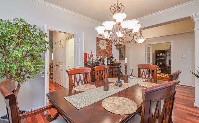 a view of a dining room with furniture a chandelier and wooden floor