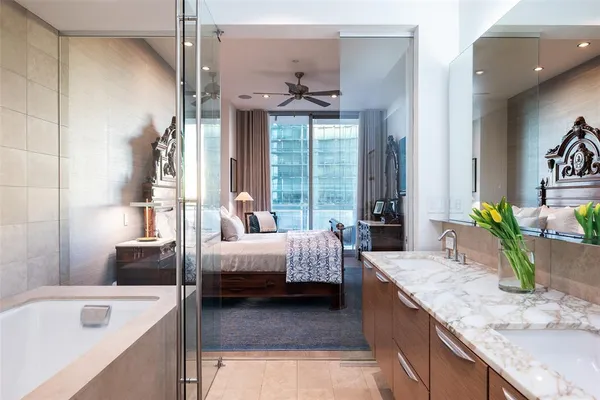 a en suite bathroom with a granite countertop tub and a large window