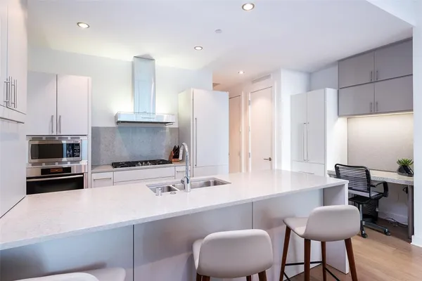 a kitchen with stainless steel appliances a sink and a refrigerator