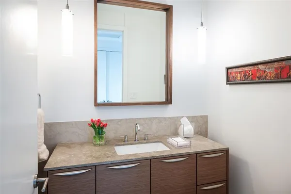 a bathroom with a granite countertop sink and a mirror