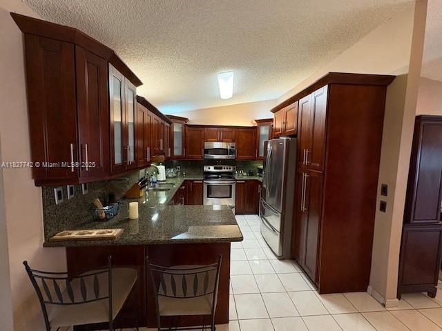 13736 Southwest 12th Street Miami, FL 33184 - Photo 6 of 14 a kitchen with stainless steel appliances granite countertop a refrigerator a stove and a sink with wooden cabinets