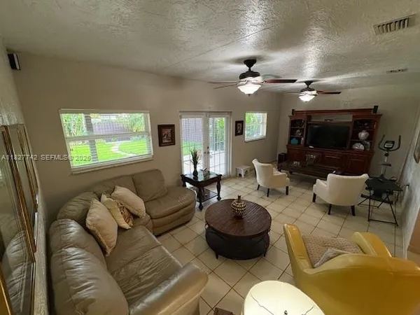 a living room with furniture a chandelier and a flat screen tv