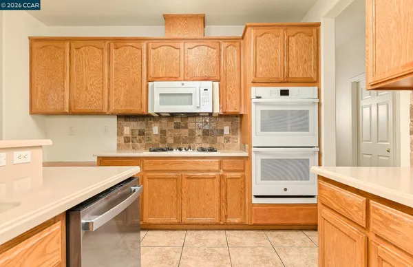 a kitchen with a refrigerator and a stove top oven