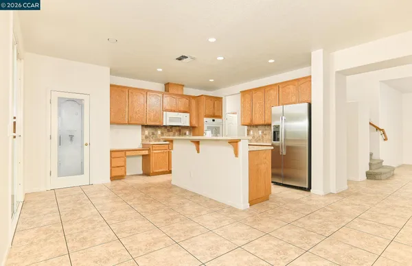 a kitchen with stainless steel appliances a refrigerator and a stove top oven