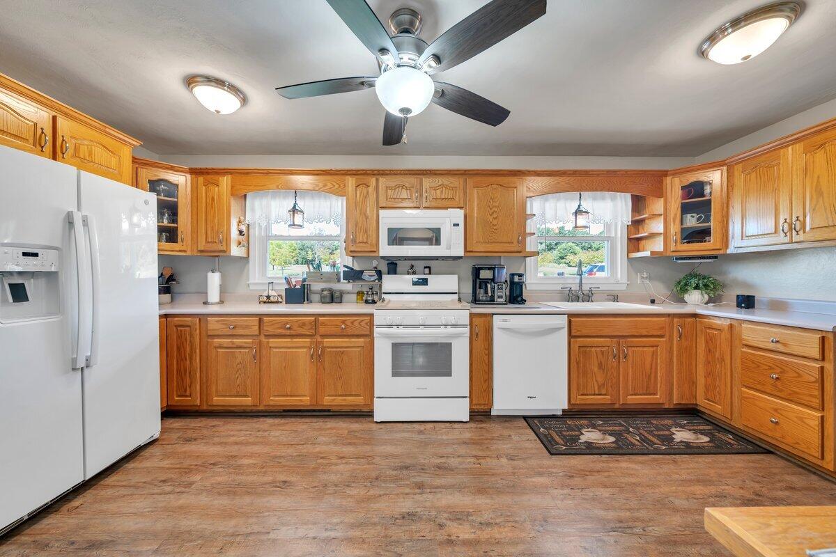 3226 Rakes Road Rocky Mount, VA 24151 - Photo 22 of 74 a kitchen with stainless steel appliances granite countertop a stove a sink dishwasher a refrigerator and white cabinets with wooden floor