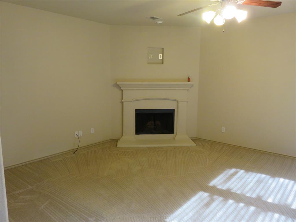 1122 Walter Stephenson Road Midlothian, TX 76065 - Photo 13 of 26 Built-in corner fireplace with a classic mantel, dark firebox, and hearth