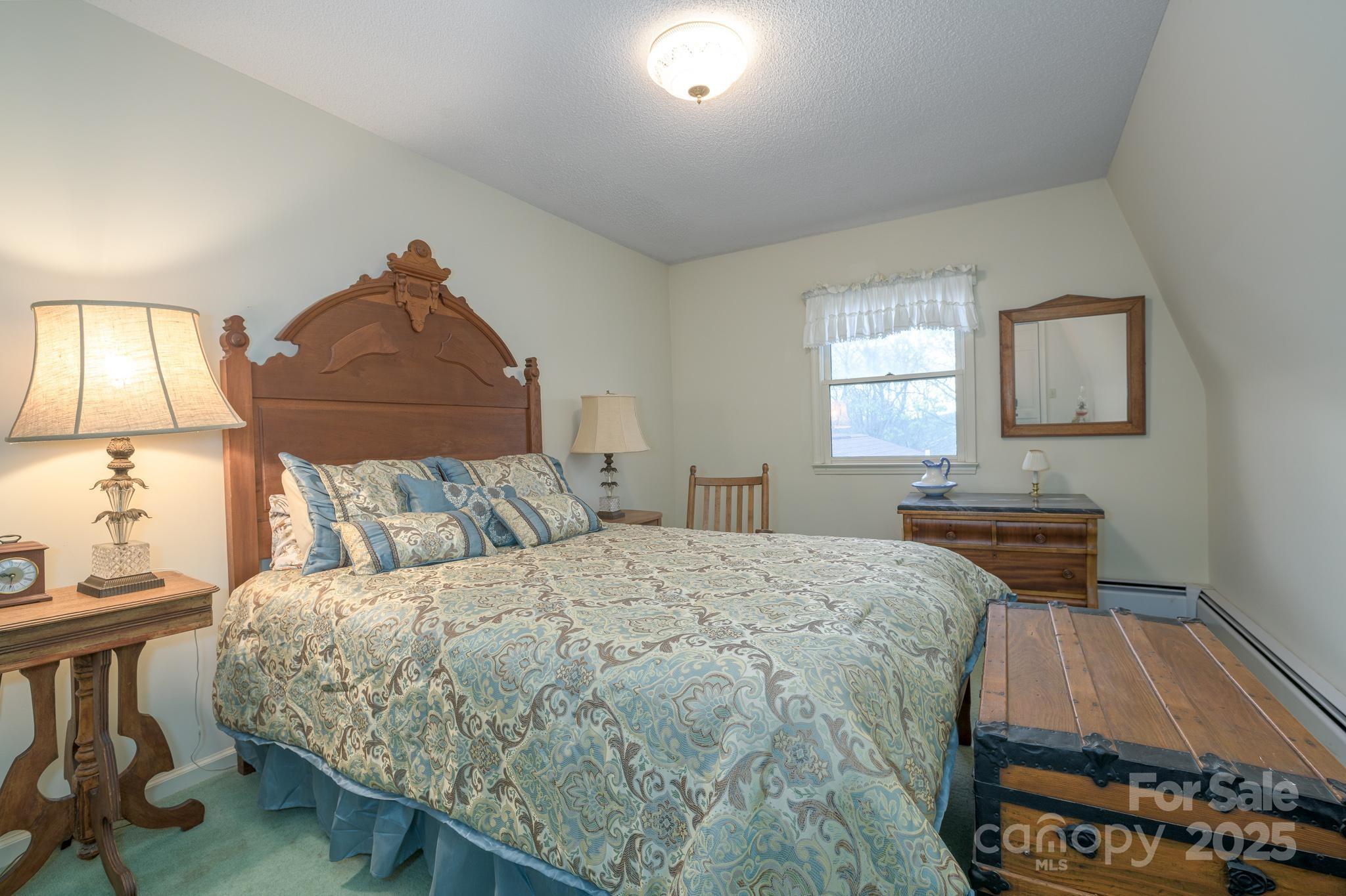 184 Buff Ridge Road Boone, NC 28607 - Photo 19 of 42 a bedroom with a bed and a dresser with mirror