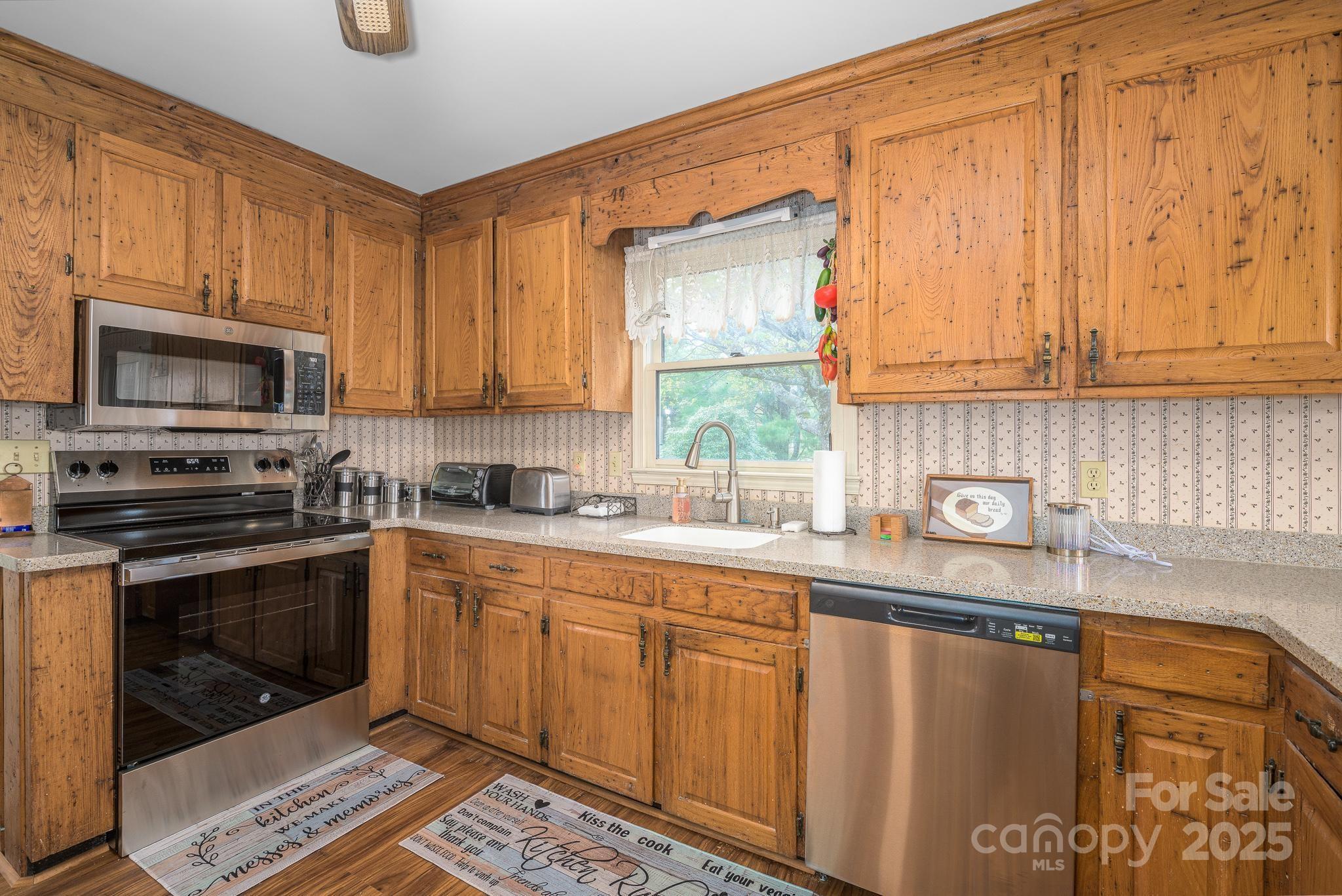 184 Buff Ridge Road Boone, NC 28607 - Photo 6 of 42 a kitchen with stainless steel appliances granite countertop a stove a sink and a microwave