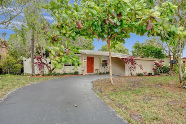 front view of a house with a yard and an trees