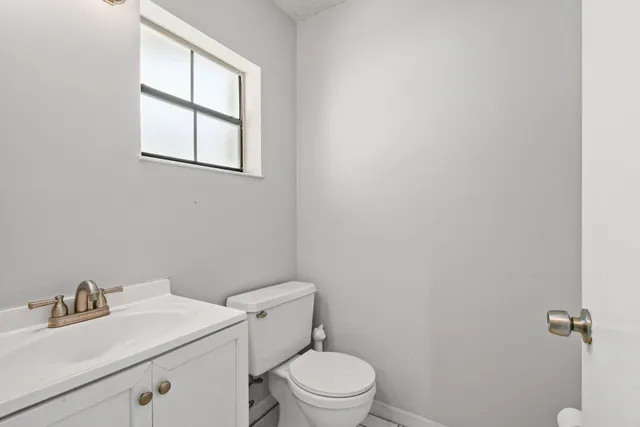 a bathroom with a sink a toilet and a window