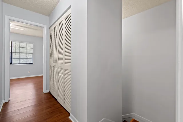 a view of a hallway with wooden floor and a window