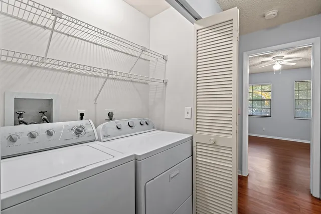 a view of washer and dryer with bathroom in the background