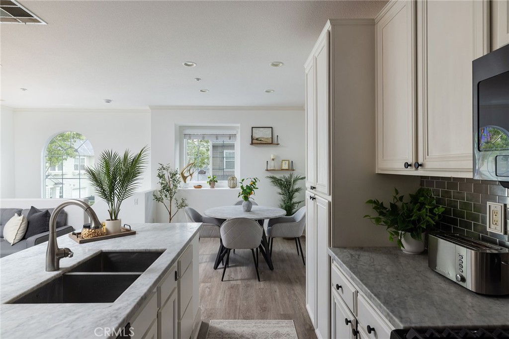34 Bayley Street Ladera Ranch, CA 92694 - Photo 11 of 24 a kitchen with granite countertop a sink a stove and white cabinets
