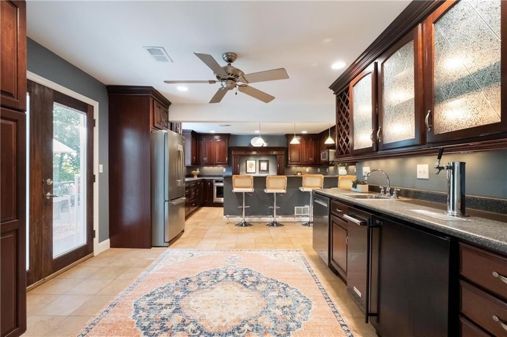 9550 Harding Road Pittsburgh, PA 15237 - Photo 11 of 44 a kitchen with stainless steel appliances kitchen island granite countertop a refrigerator a sink and wooden cabinets