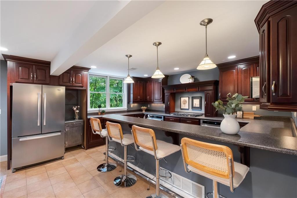9550 Harding Road Pittsburgh, PA 15237 - Photo 12 of 44 a kitchen with refrigerator a sink and chairs