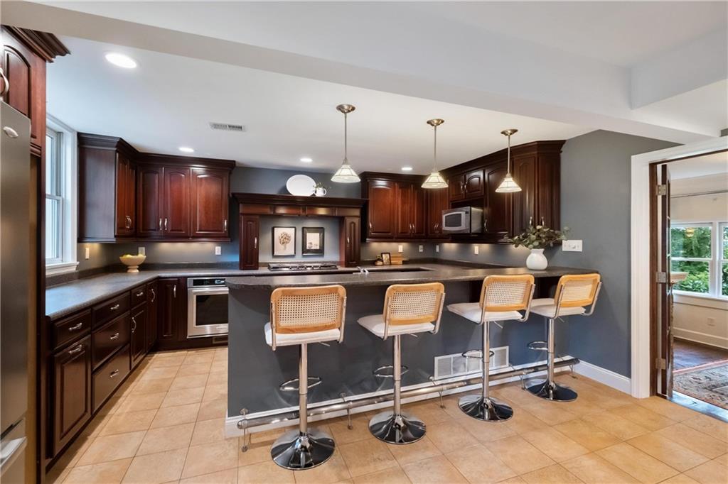 9550 Harding Road Pittsburgh, PA 15237 - Photo 13 of 44 a kitchen with stainless steel appliances kitchen island granite countertop a sink and cabinets