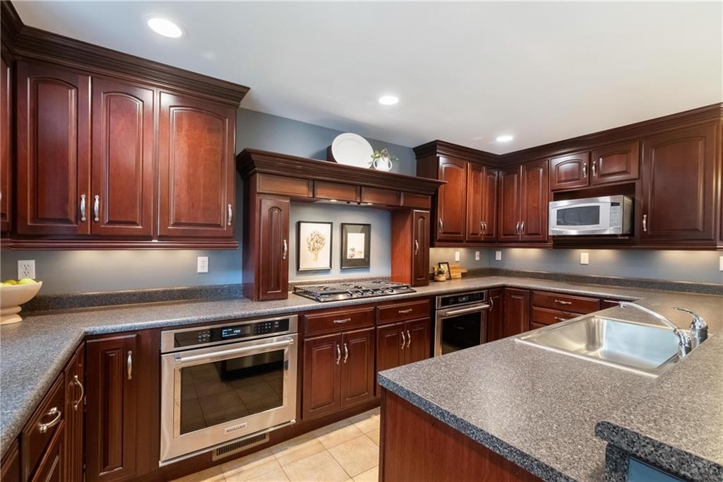 9550 Harding Road Pittsburgh, PA 15237 - Photo 14 of 44 a kitchen with granite countertop stainless steel appliances and wooden cabinets