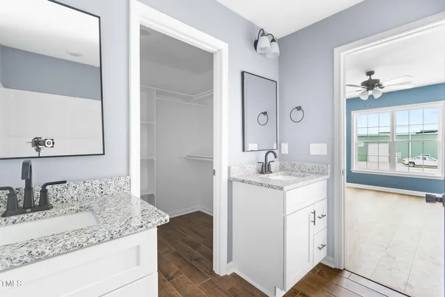 a bathroom with a granite countertop sink a mirror and a shower