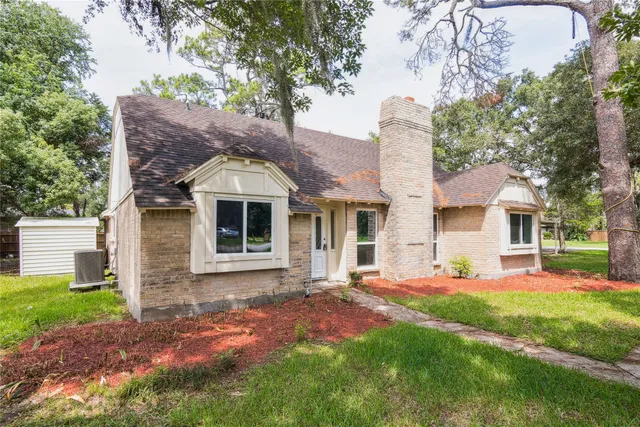 a front view of a house with a garden and yard