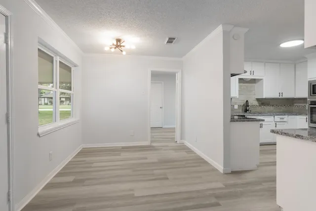 a kitchen with granite countertop white cabinets and a sink