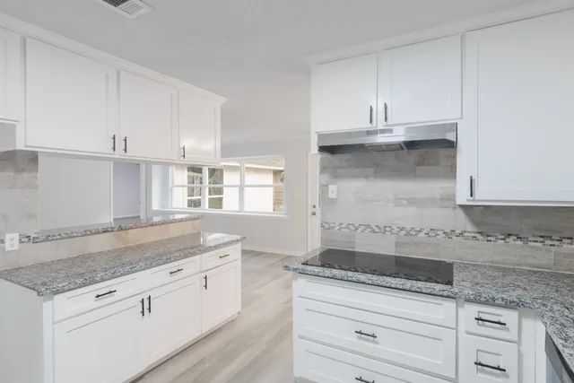 a kitchen with granite countertop a sink and cabinets