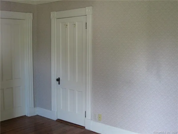 an empty room with wooden floor and a window