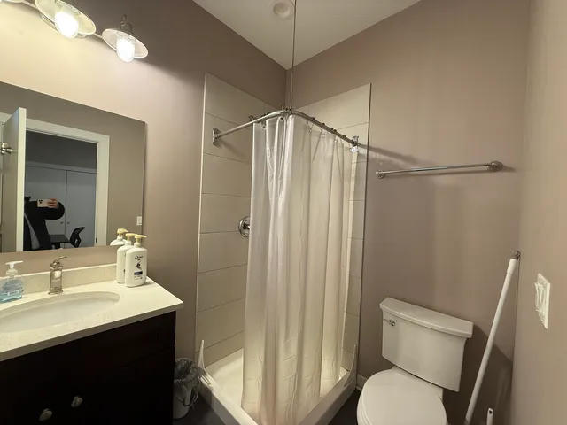 a bathroom with a sink a toilet a shower and a mirror