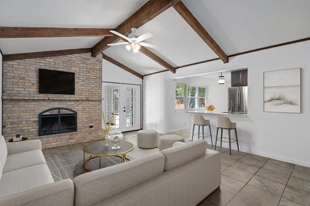 a living room with furniture a fireplace and a flat screen tv