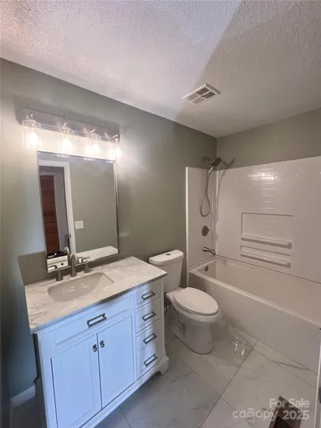 a spacious bathroom with a double vanity sink toilet mirror and shower