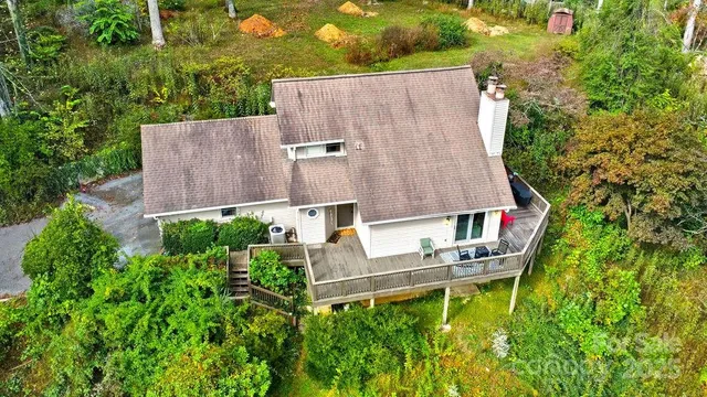an aerial view of a house with a backyard and trees