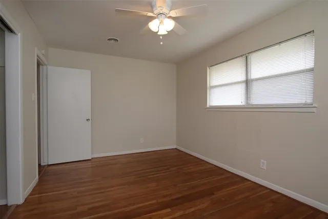 a view of a room with wooden floor and a window